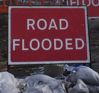 Road Flooded sign and sandbags